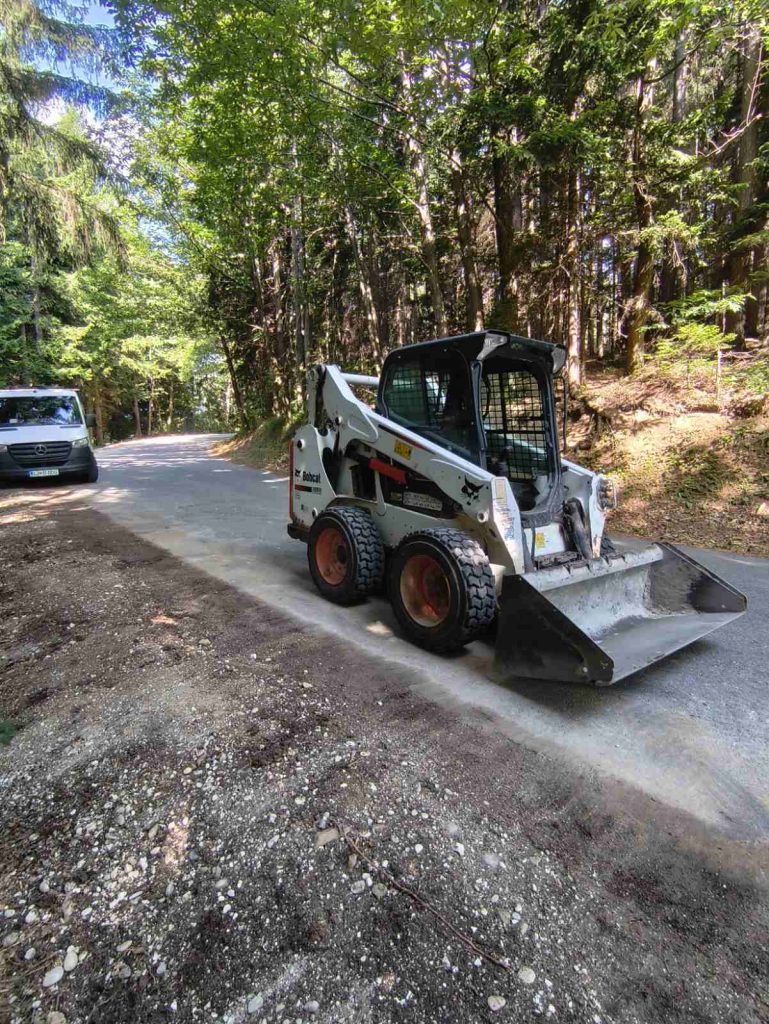 Nakladalec Bobcat na gozdni cesti med deli na optičnem omrežju